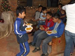 Manuel feeds other children at a special feeding event  near the orphanage. 