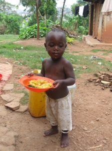 A happy child in Uganda now with a hot meal!