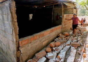 One Mother inspects the damage to her house. She must now find safe shelter and food for her family. 